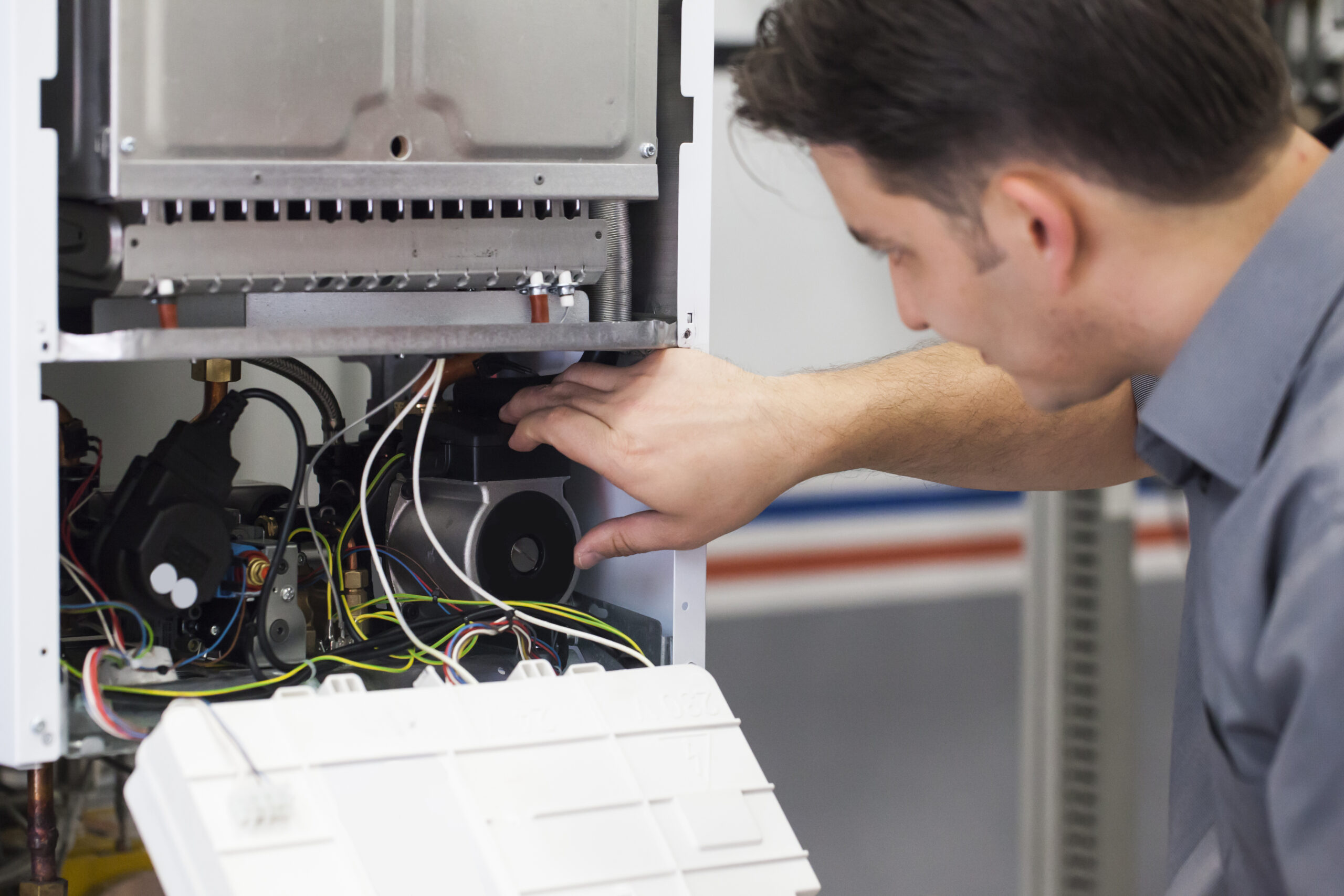 A service technician repairs a boiler.