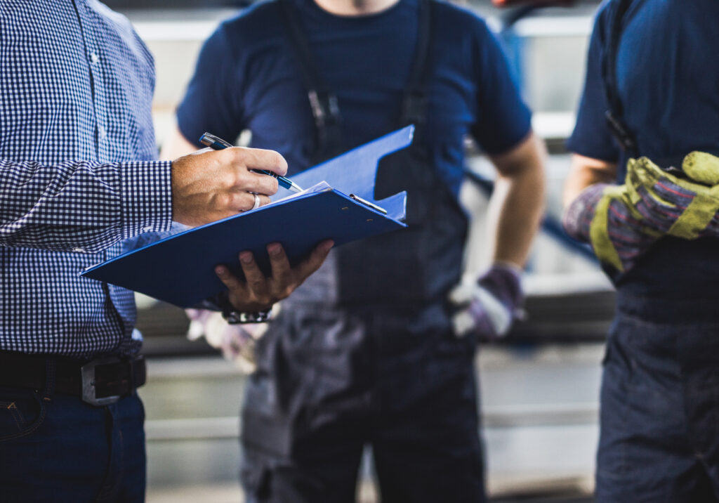 Three workers gather to plan maintenance